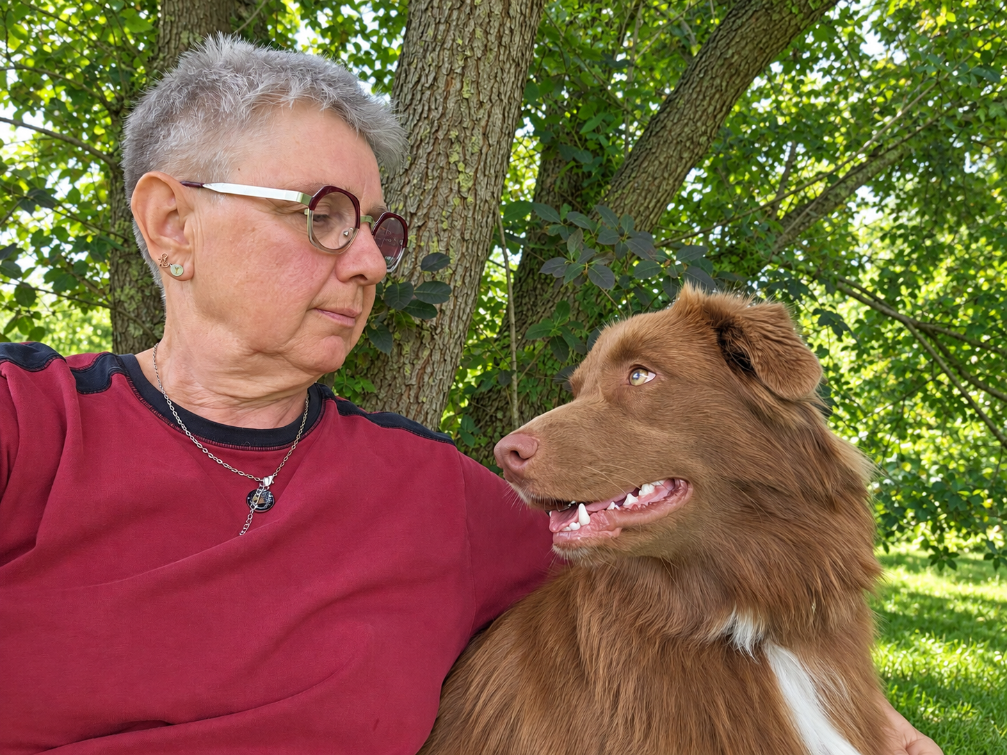 Hundetrainerin Gilla mit einem Hund im Grünen